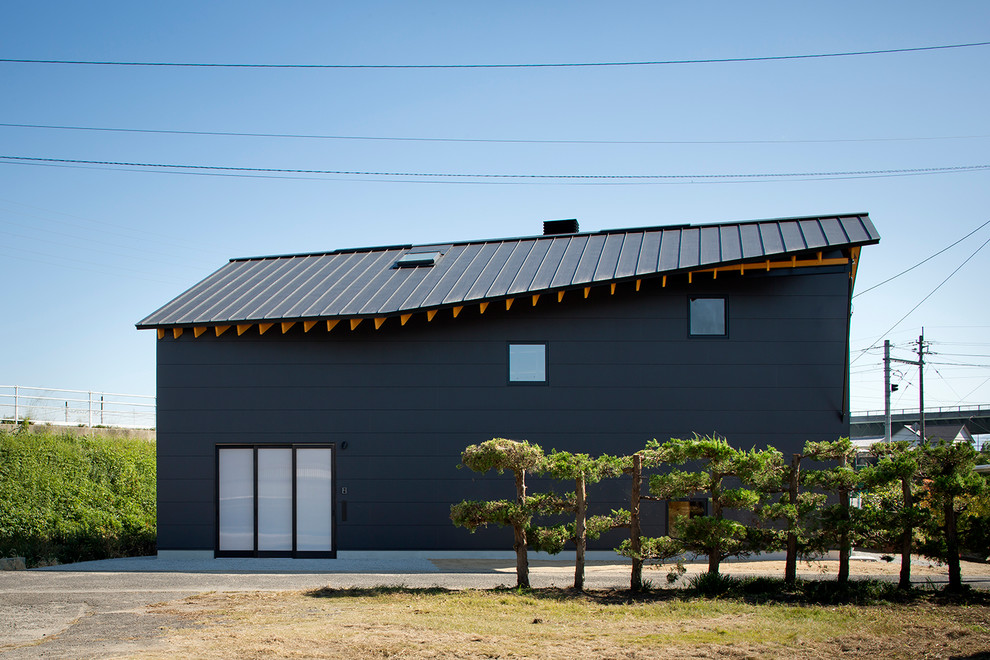 Exemple d'une façade de maison noire montagne à un étage avec un revêtement mixte, un toit à deux pans et un toit en métal.