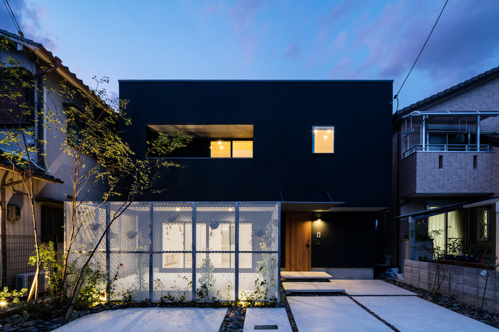 Réalisation d'une façade de maison noire asiatique à un étage avec un toit plat.