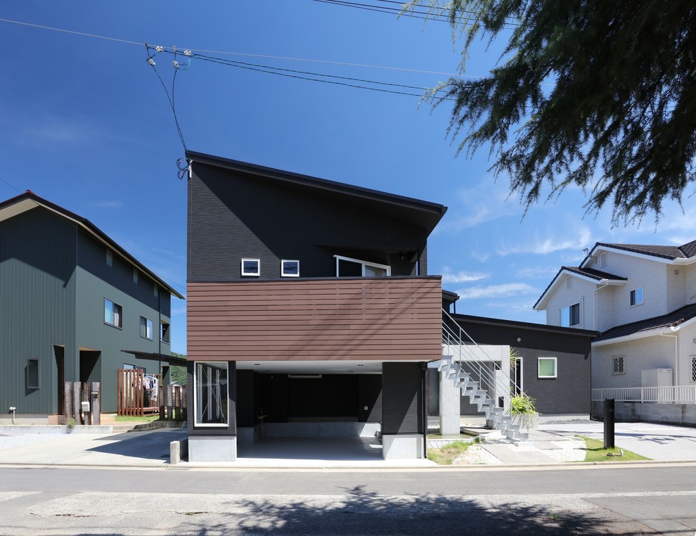 Идея дизайна: маленький, двухэтажный, черный частный загородный дом в современном стиле с комбинированной облицовкой, односкатной крышей и металлической крышей для на участке и в саду