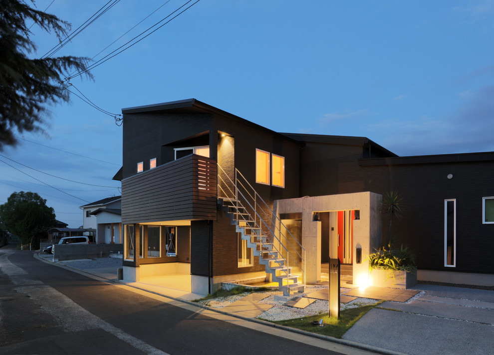 На фото: маленький, двухэтажный, черный частный загородный дом в современном стиле с комбинированной облицовкой, односкатной крышей и металлической крышей для на участке и в саду