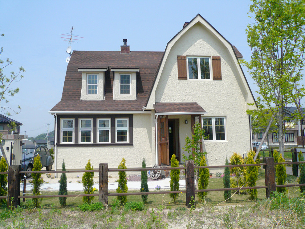 Modelo de fachada de casa beige campestre de dos plantas con tejado a doble faldón