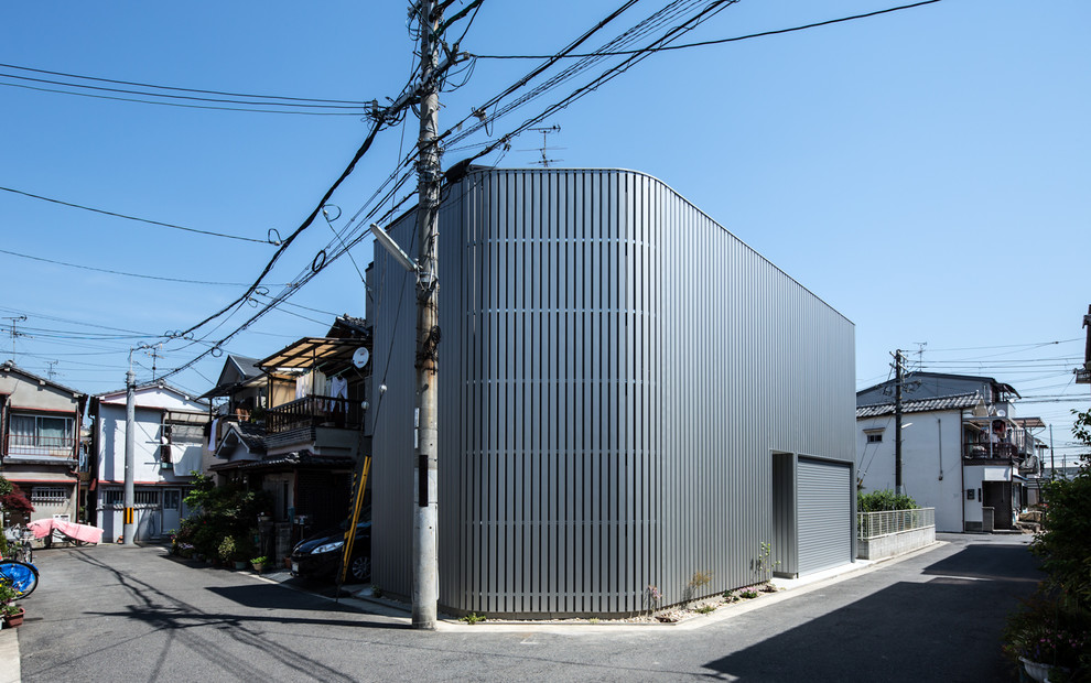 Imagen de fachada de casa gris moderna de tamaño medio de dos plantas con revestimiento de metal, tejado plano y tejado de metal