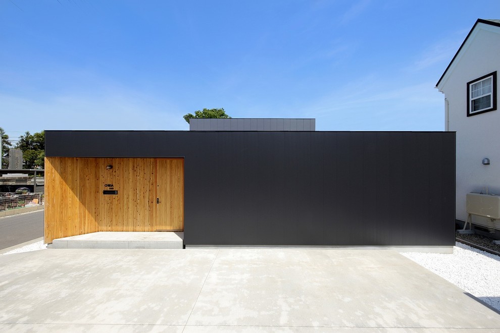 Inspiration för ett litet funkis svart hus, med allt i ett plan, metallfasad, platt tak och tak i metall