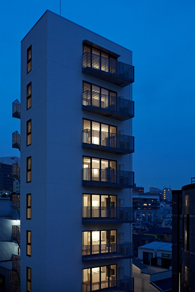 Foto della facciata di un appartamento bianco moderno a tre piani con tetto piano