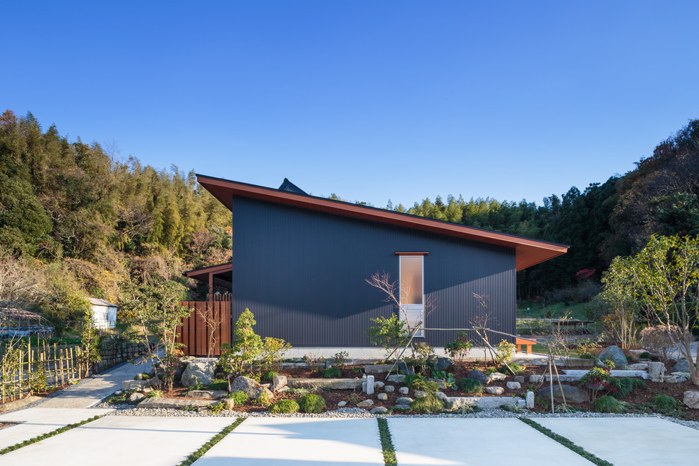 Idées déco pour une façade de maison bleue asiatique de plain-pied avec un toit en appentis.