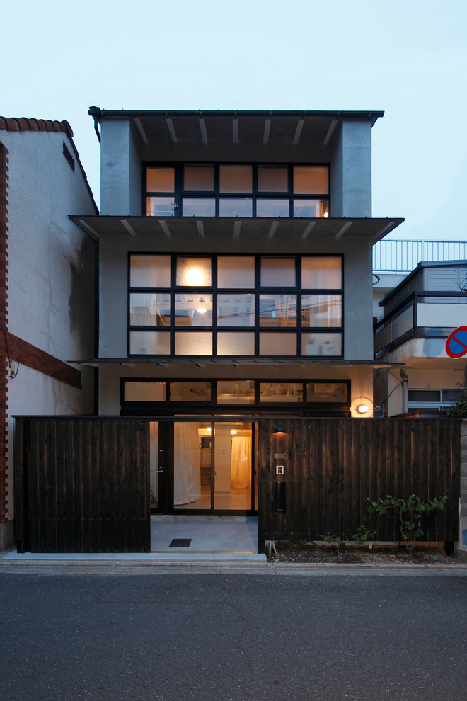 Cette photo montre une façade de maison grise asiatique à deux étages et plus avec un toit plat.