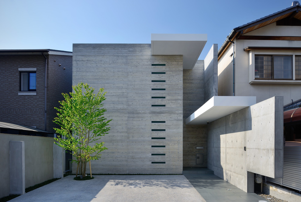 Пример оригинального дизайна: двухэтажный, серый дом в стиле модернизм с облицовкой из бетона