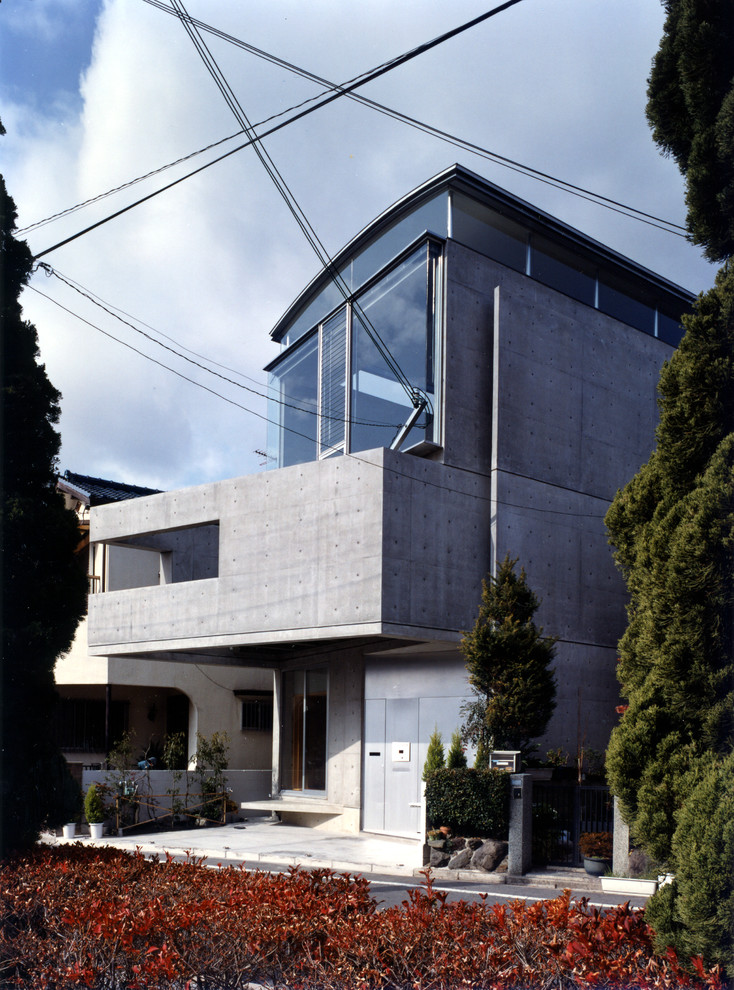 Aménagement d'une petite façade de maison grise moderne en béton à deux étages et plus avec un toit en métal.