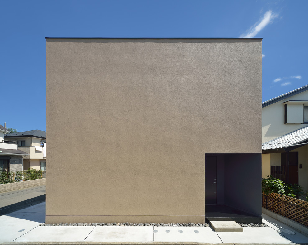 Cette image montre une façade de maison beige minimaliste de taille moyenne avec un revêtement mixte et un toit plat.