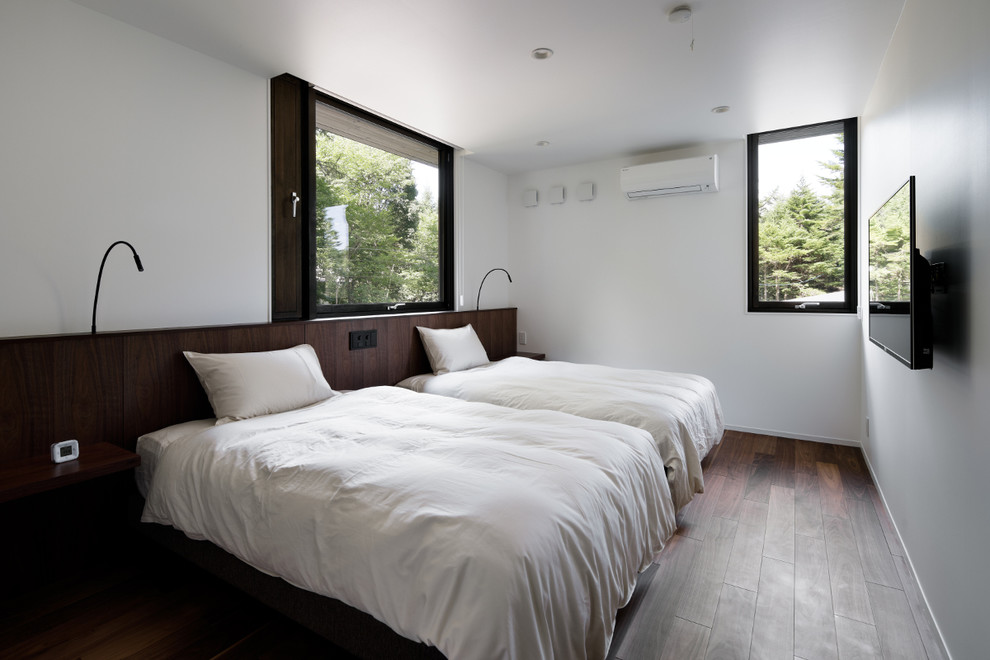 Imagen de dormitorio principal tradicional con paredes blancas, suelo de madera oscura y suelo marrón
