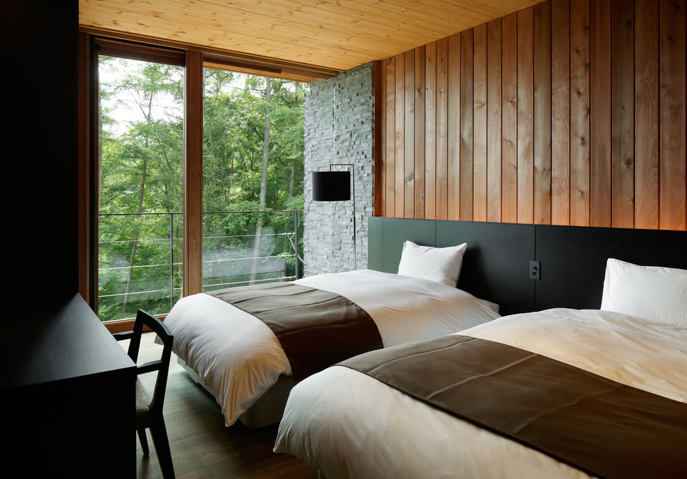 Immagine di una camera da letto moderna con pareti marroni e parquet scuro