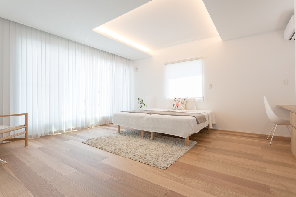 Scandi master bedroom in Other with white walls, light hardwood flooring and beige floors.
