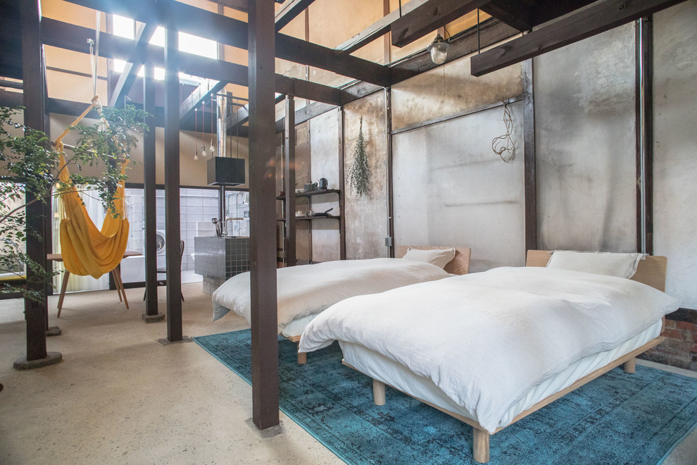 Immagine di una camera da letto etnica con pareti grigie, pavimento in cemento e pavimento grigio