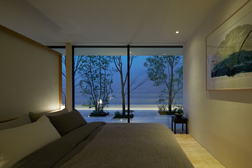 Пример оригинального дизайна: хозяйская спальня в стиле модернизм с белыми стенами, полом из травертина и бежевым полом