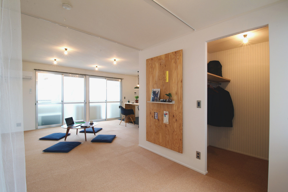 Imagen de dormitorio principal nórdico con paredes blancas, suelo de corcho, suelo marrón y papel pintado