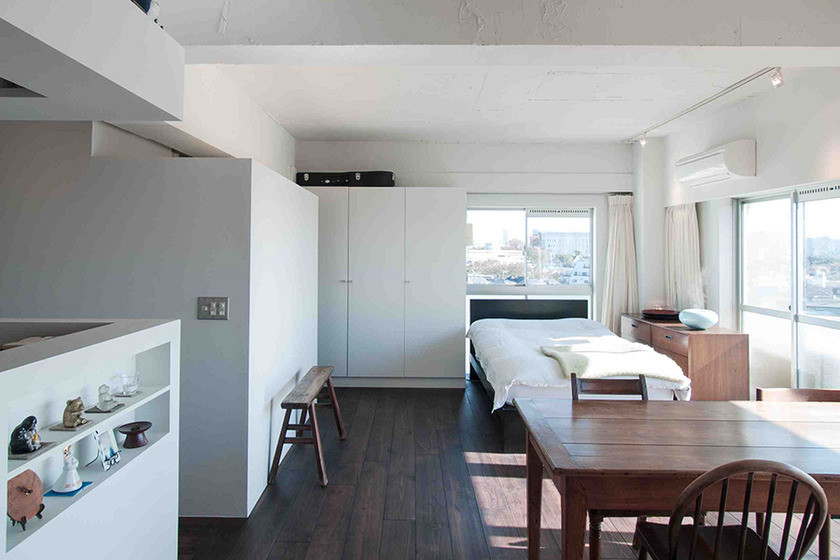 Kleines Modernes Hauptschlafzimmer ohne Kamin mit weißer Wandfarbe und dunklem Holzboden in Tokio