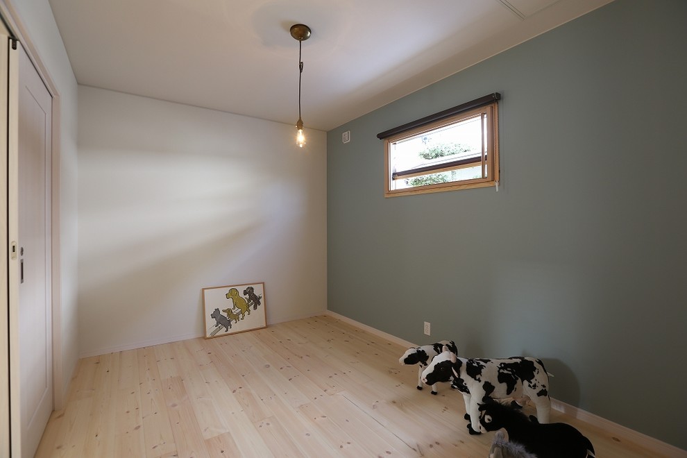 Asiatisches Hauptschlafzimmer mit grauer Wandfarbe und braunem Holzboden in Sonstige