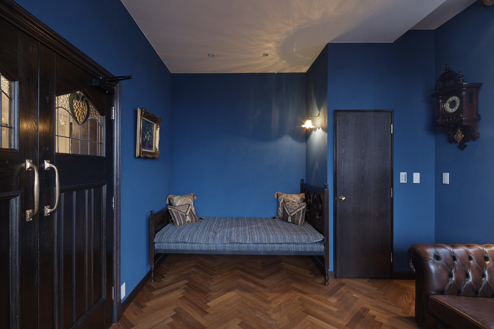 他の地域にあるトラディショナルスタイルのおしゃれな寝室 (青い壁、無垢フローリング、茶色い床) のレイアウト