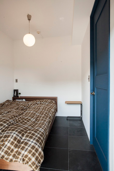 Идея дизайна: маленькая хозяйская спальня в стиле модернизм с белыми стенами и полом из сланца без камина для на участке и в саду