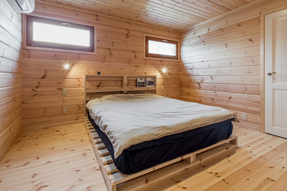 This is an example of a rustic bedroom in Other with beige walls, light hardwood flooring and beige floors.