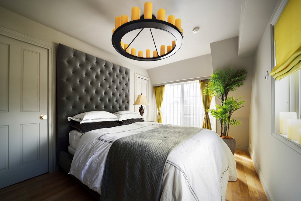 Idée de décoration pour une chambre design avec un mur gris, un sol en bois brun et un sol marron.