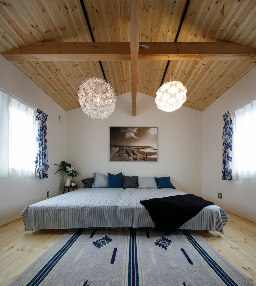 Inspiration för maritima sovrum, med vita väggar, ljust trägolv och beiget golv