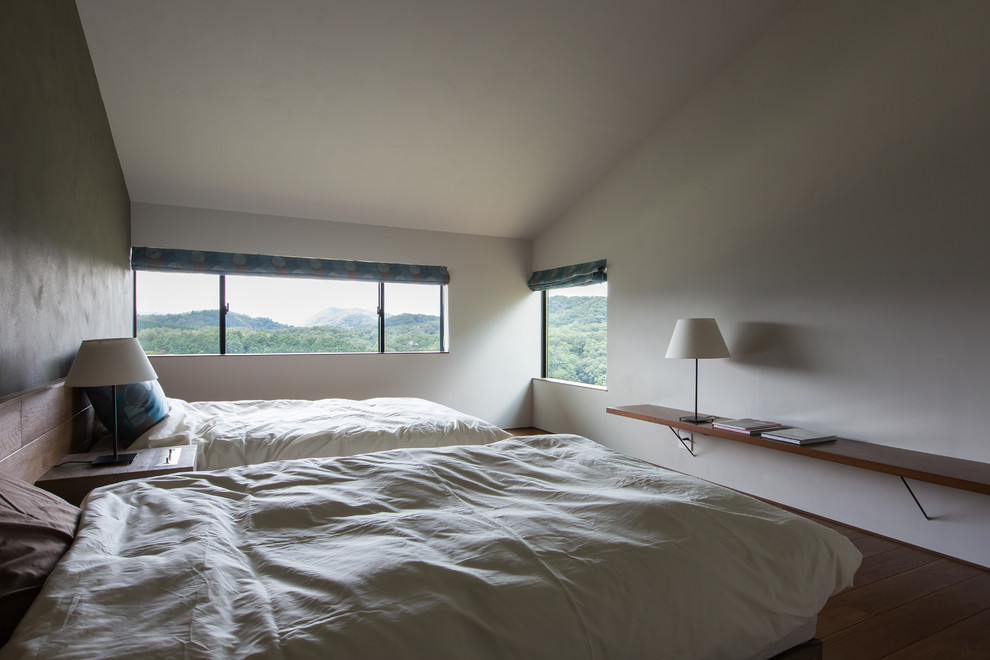 This is an example of a modern bedroom in Osaka with white walls and medium hardwood flooring.