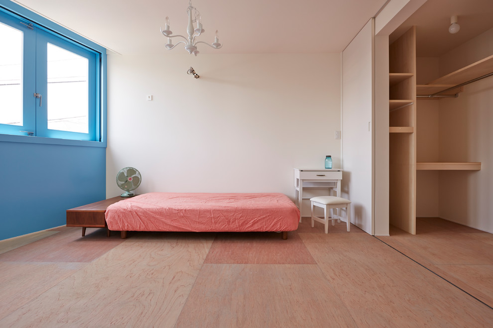 Idée de décoration pour une petite chambre parentale bohème avec un mur blanc, un sol en bois brun et un sol beige.