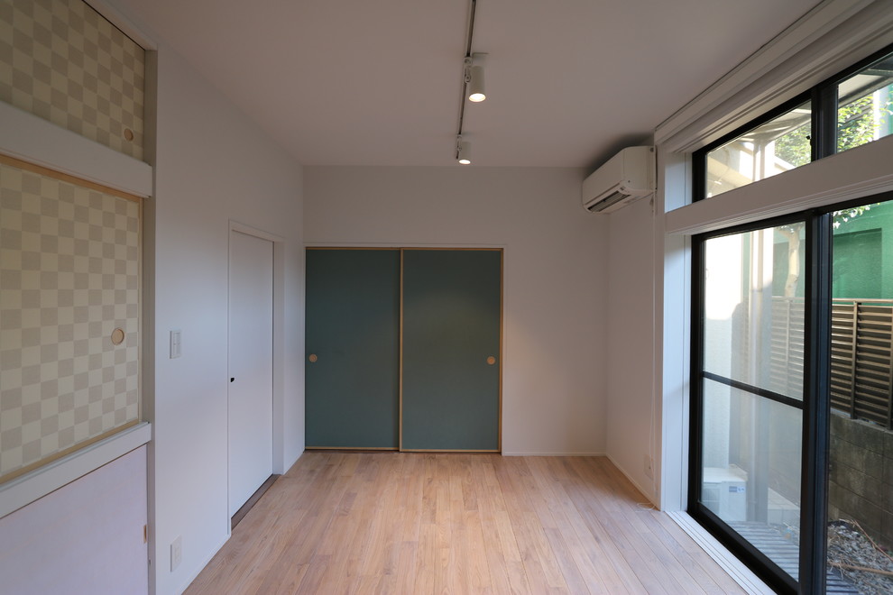 Exempel på ett mellanstort modernt huvudsovrum, med vita väggar, ljust trägolv och beiget golv