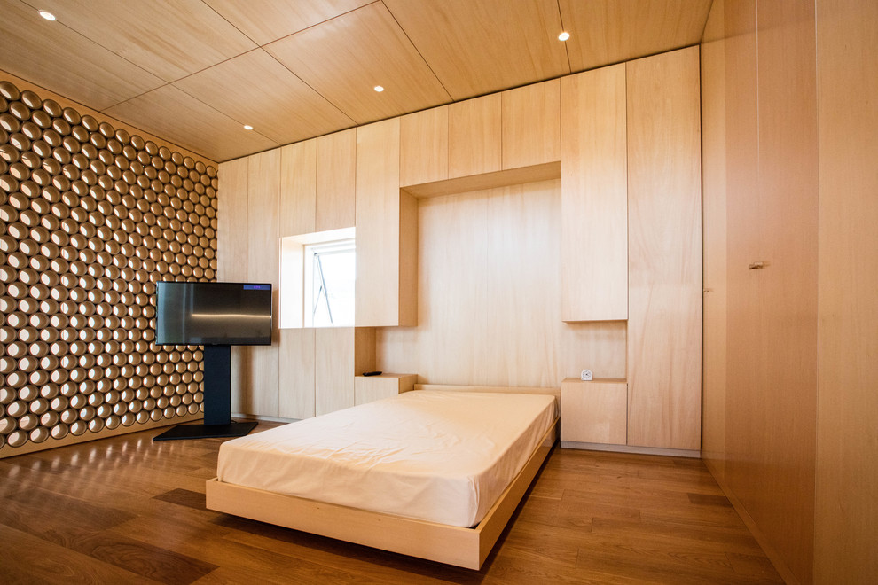 Foto de dormitorio minimalista con paredes marrones, suelo de madera en tonos medios y suelo marrón