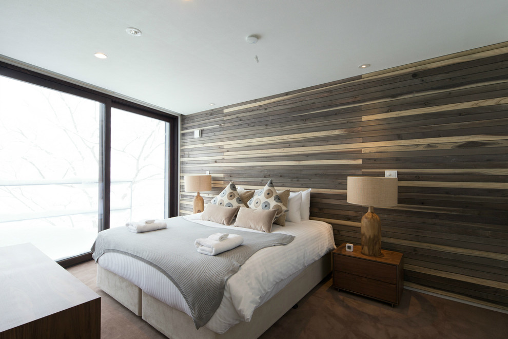 Imagen de dormitorio actual con paredes marrones y moqueta