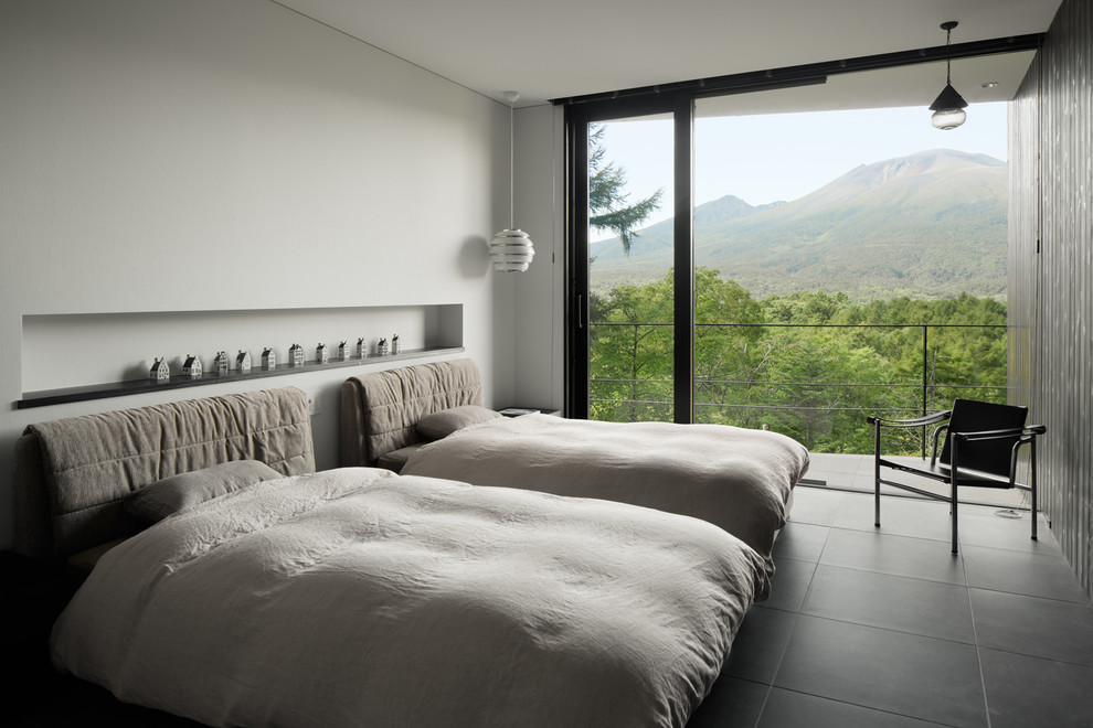 Immagine di una camera da letto minimalista con pareti bianche e pavimento nero