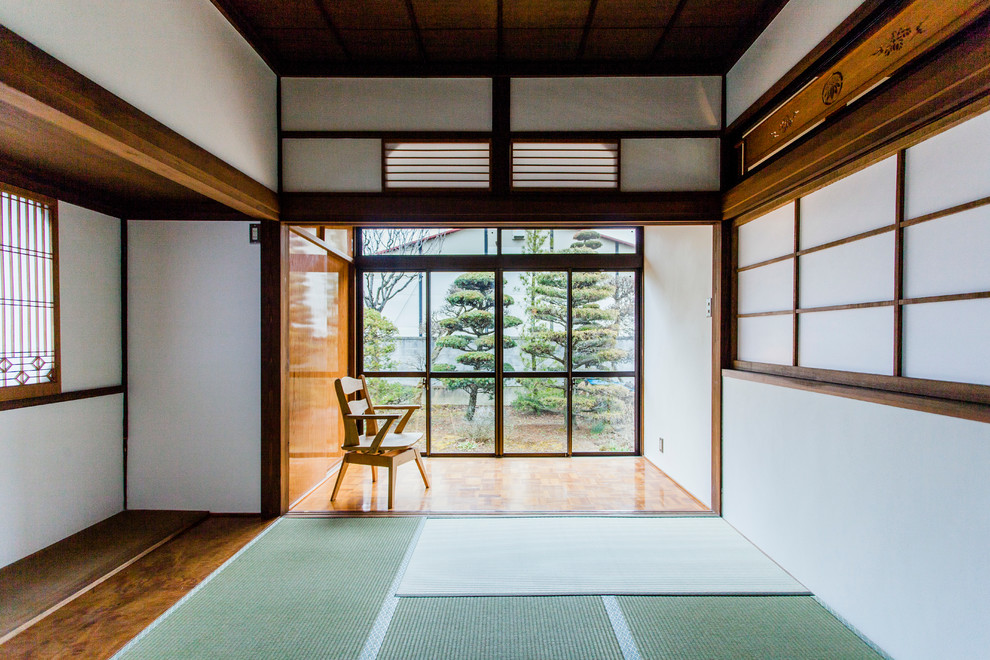 Foto di una camera da letto etnica con pareti bianche, pavimento in tatami e pavimento verde