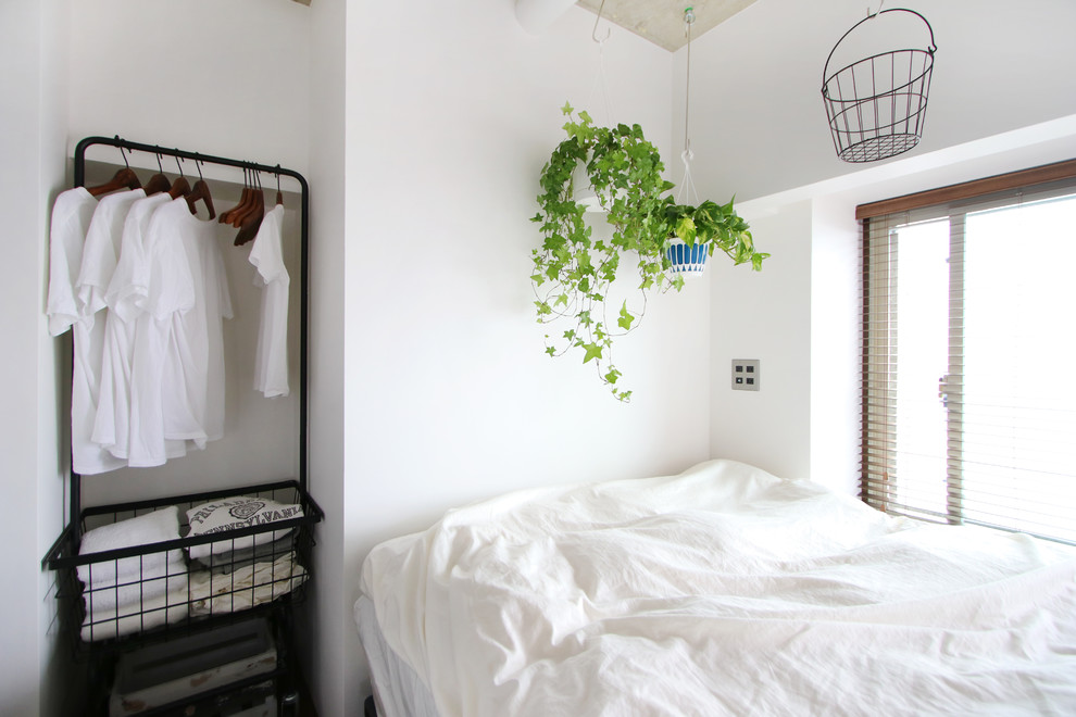 На фото: гостевая спальня (комната для гостей) в стиле лофт с белыми стенами