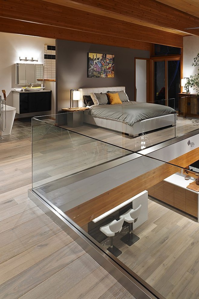 Idee per un'In mansarda camera da letto stile loft design con pareti grigie e parquet chiaro