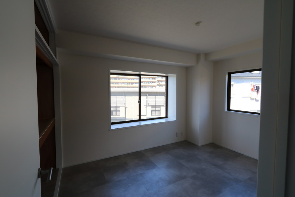 Cette image montre une petite chambre parentale minimaliste avec un mur blanc, un sol en vinyl, aucune cheminée et un sol multicolore.