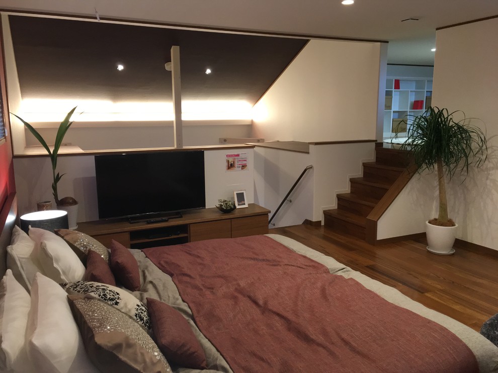 Immagine di una grande camera matrimoniale minimalista con pavimento in legno verniciato
