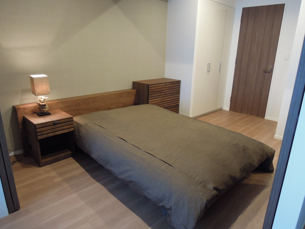 Kleines Asiatisches Hauptschlafzimmer mit grüner Wandfarbe, beigem Boden und Sperrholzboden in Tokio