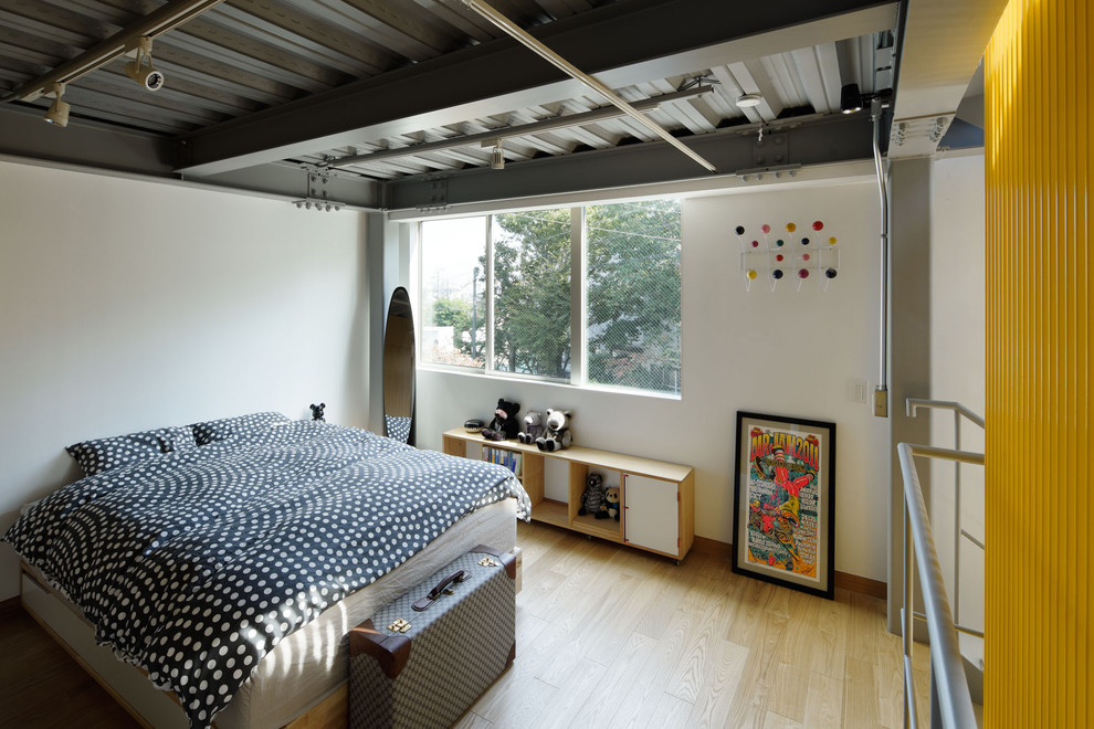 Diseño de dormitorio urbano con paredes blancas, suelo de madera clara y suelo marrón