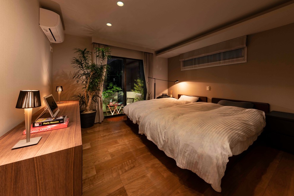 Large contemporary master bedroom in Yokohama with white walls, plywood flooring and brown floors.