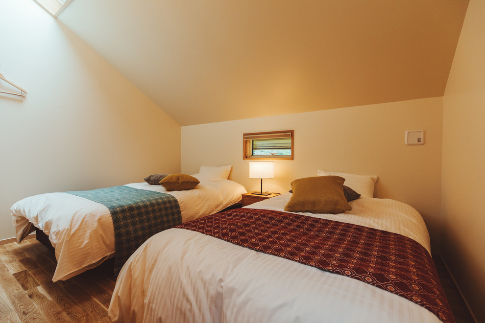 Kleines Landhaus Schlafzimmer ohne Kamin mit weißer Wandfarbe, braunem Holzboden und beigem Boden in Sonstige