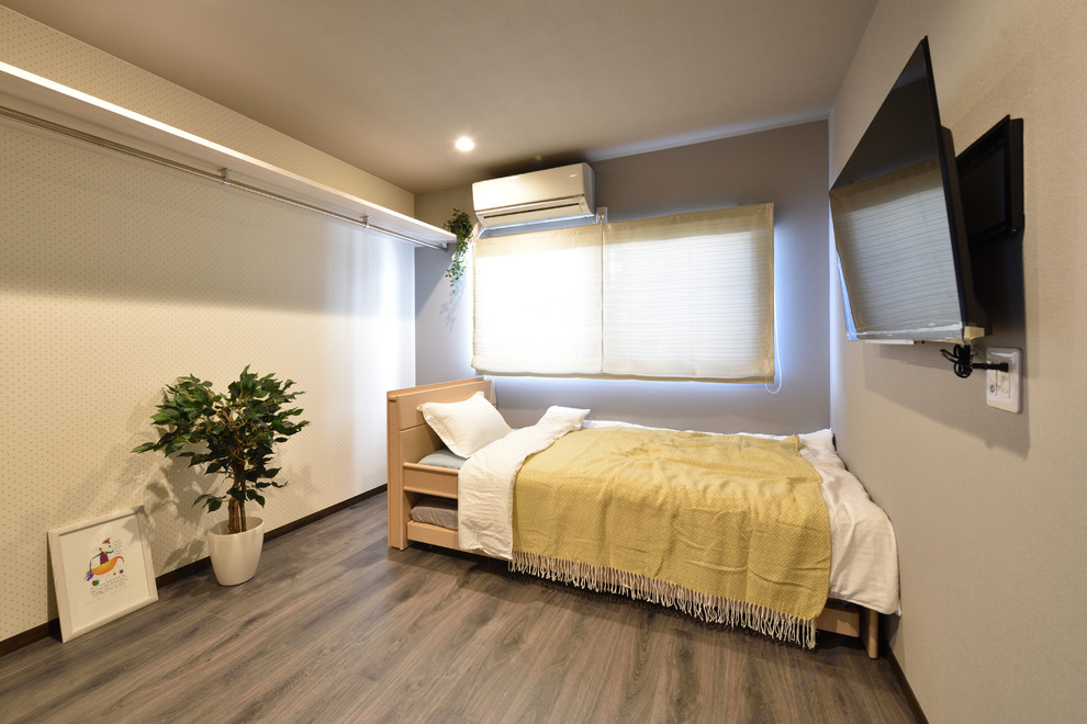 Foto di una piccola camera da letto moderna con pareti bianche, pavimento in legno verniciato e pavimento grigio