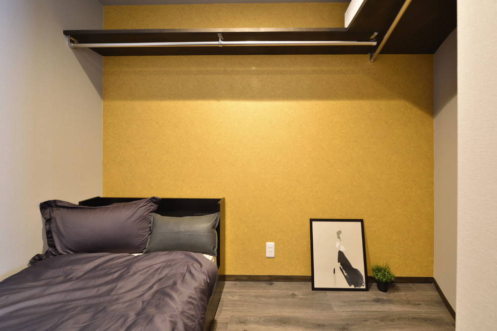 Diseño de dormitorio minimalista pequeño con paredes amarillas, suelo de madera pintada y suelo gris