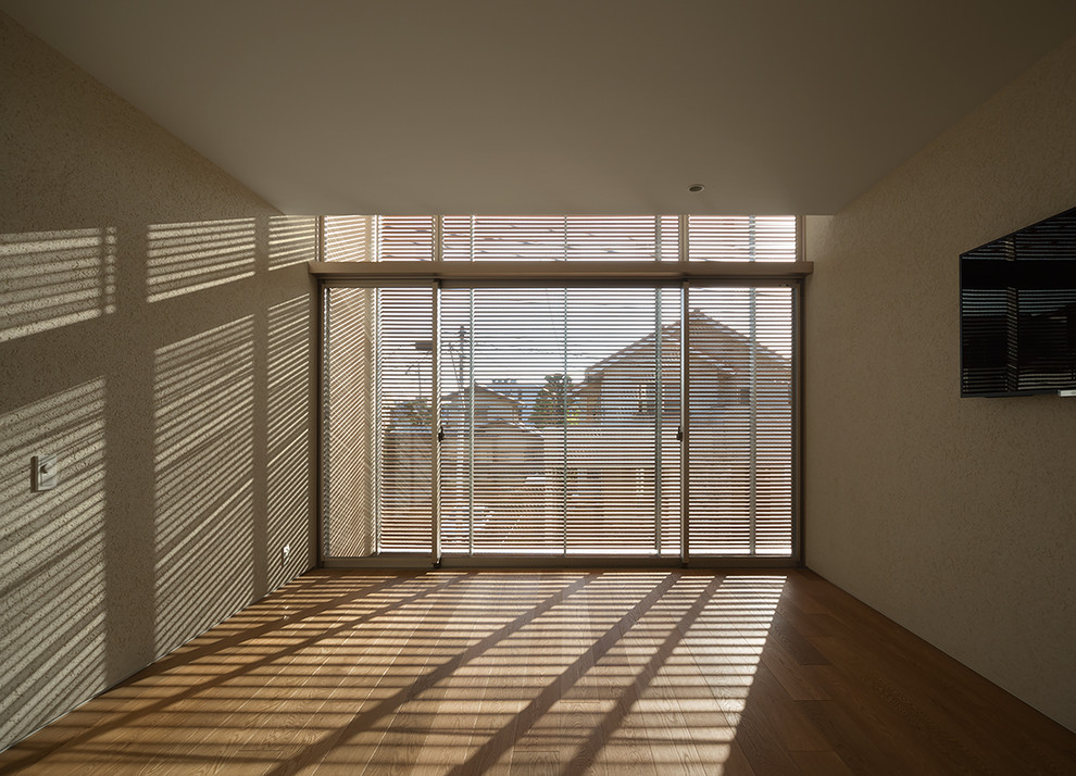 Modelo de dormitorio principal minimalista con paredes blancas, suelo de contrachapado y suelo marrón