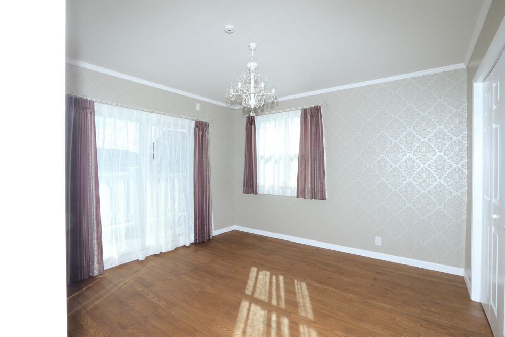 Aménagement d'une chambre d'amis victorienne avec un mur rose, un sol en bois brun, un sol marron, un plafond décaissé et du papier peint.