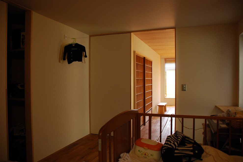 Ejemplo de dormitorio principal minimalista con paredes beige, suelo de madera oscura y suelo marrón
