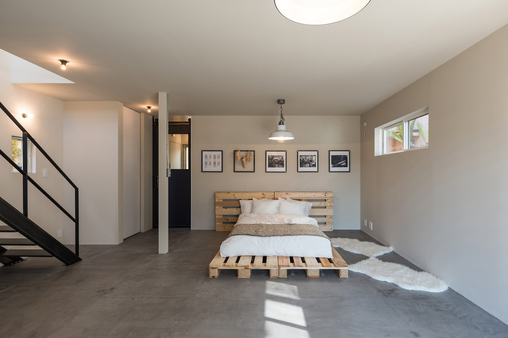 他の地域にあるコンテンポラリースタイルのおしゃれな寝室 (白い壁、コンクリートの床、グレーの床)