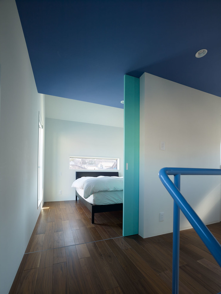 Imagen de dormitorio principal minimalista de tamaño medio sin chimenea con paredes verdes, suelo de contrachapado y suelo marrón