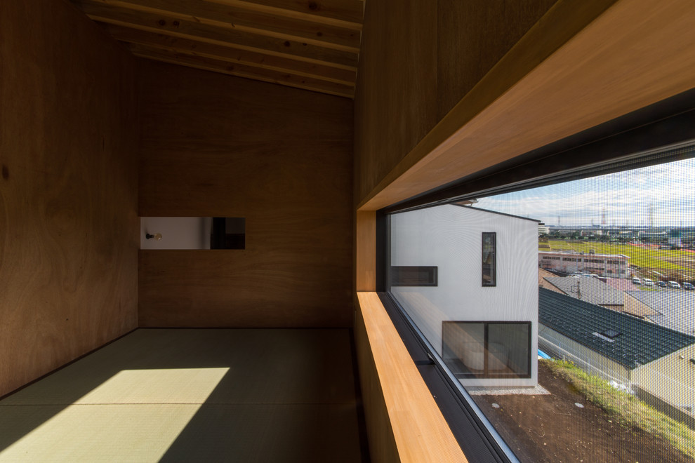 Idee per una camera da letto stile loft etnica di medie dimensioni con pareti bianche, pavimento in tatami, stufa a legna, cornice del camino in cemento e pavimento beige