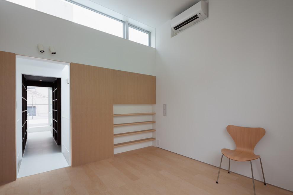 Imagen de dormitorio principal minimalista sin chimenea con paredes blancas, suelo de contrachapado y suelo beige